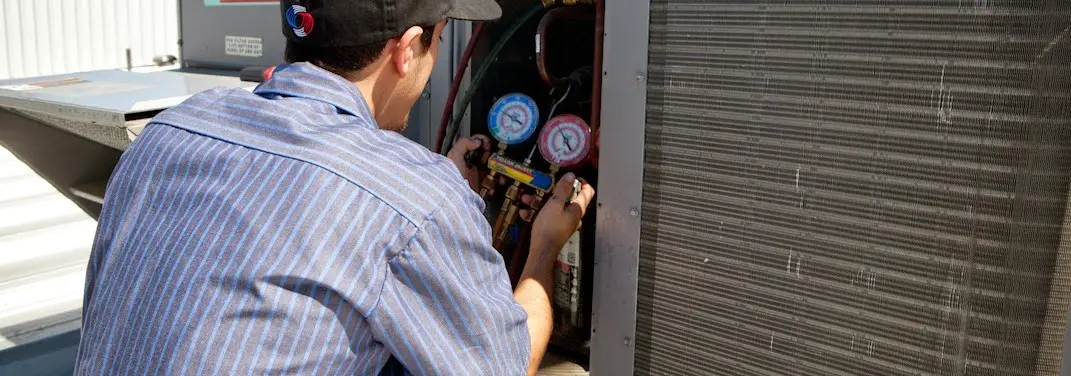 HVAC technician servicing a condenser unit in Brookfield